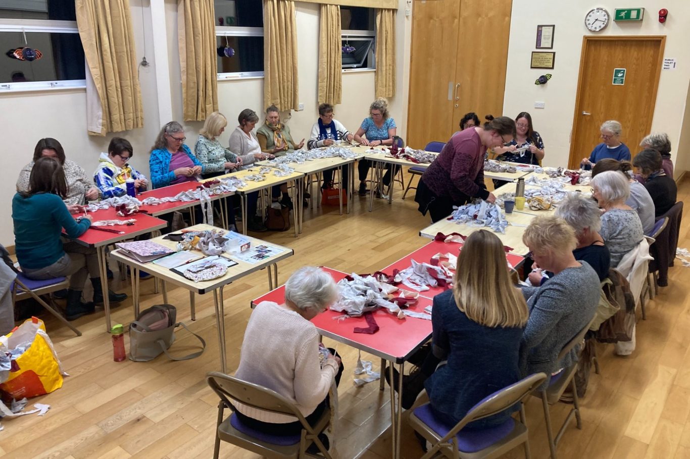 A group of people gathered around tables engaged in a crafting activity.